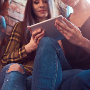 Geburtstag_0001_group-of-female-friends-in-casual-clothes-discussing-while-looking-something-on-a-digital-tablet-in-a-ro